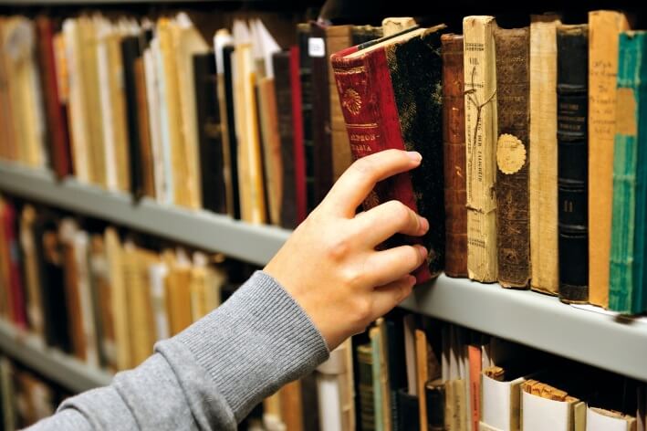 Oud boek dat uit schap wordt gehaald